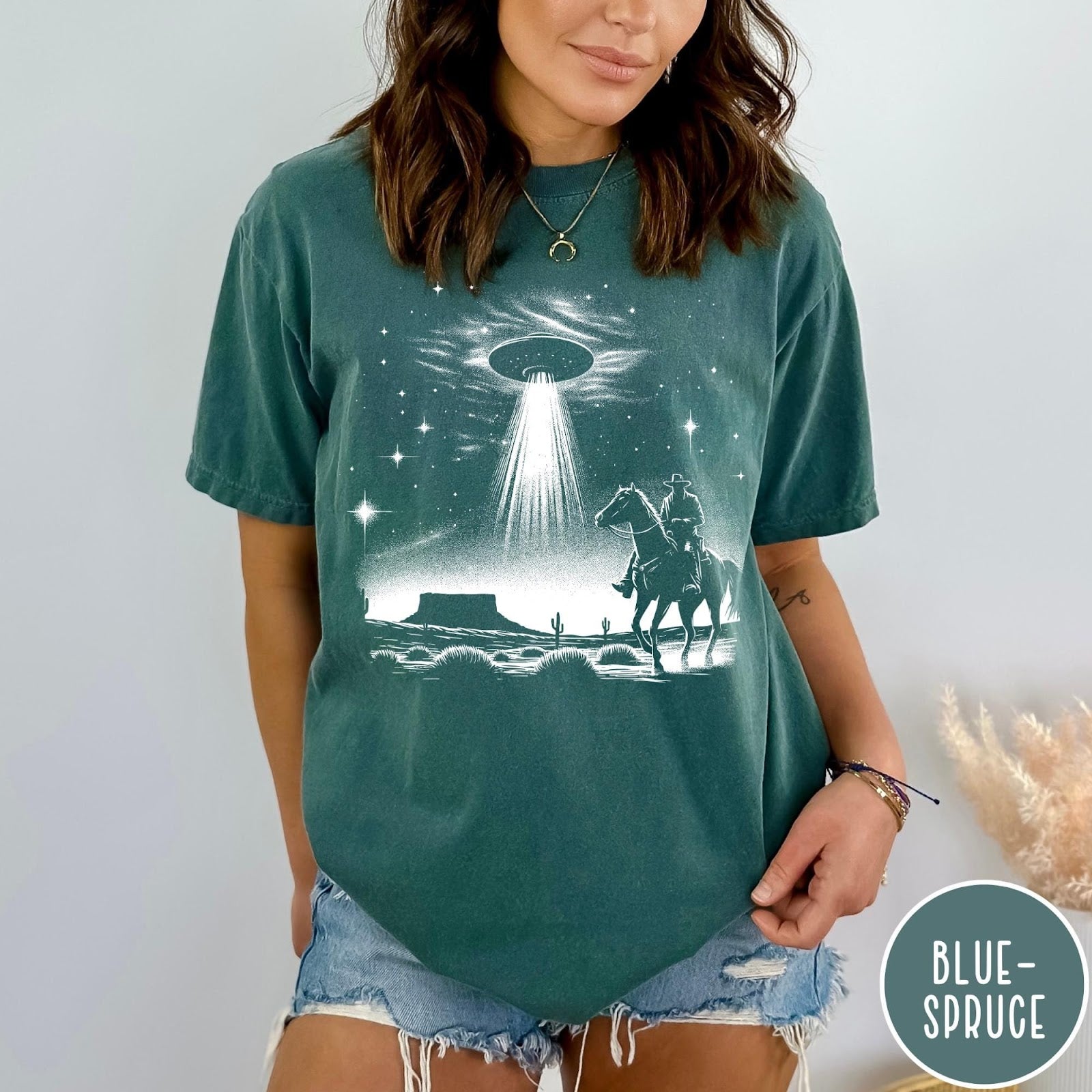 Comfort Colors tee in Blue Spruce featuring western graphic style with a cowboy riding a horse under a UFO