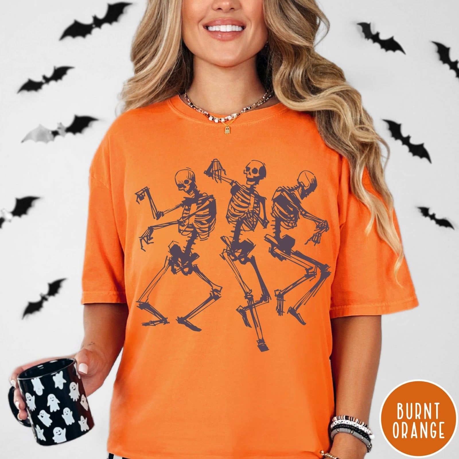 Comfort Colors tee in Burnt Orange featuring dancing skeletons graphic illustration on the front of the shirt