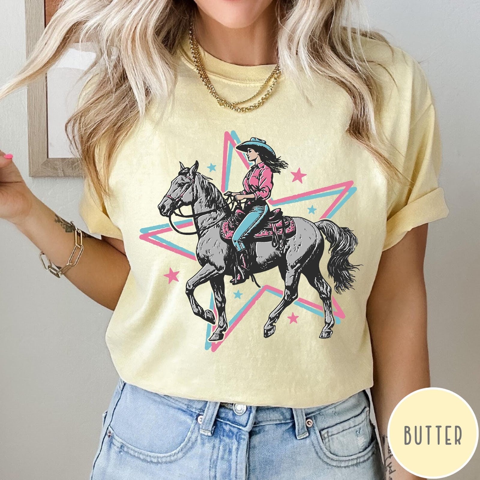 Comfort Colors tee in Butter featuring retro cowgirl graphic with a woman riding a horse inside a star