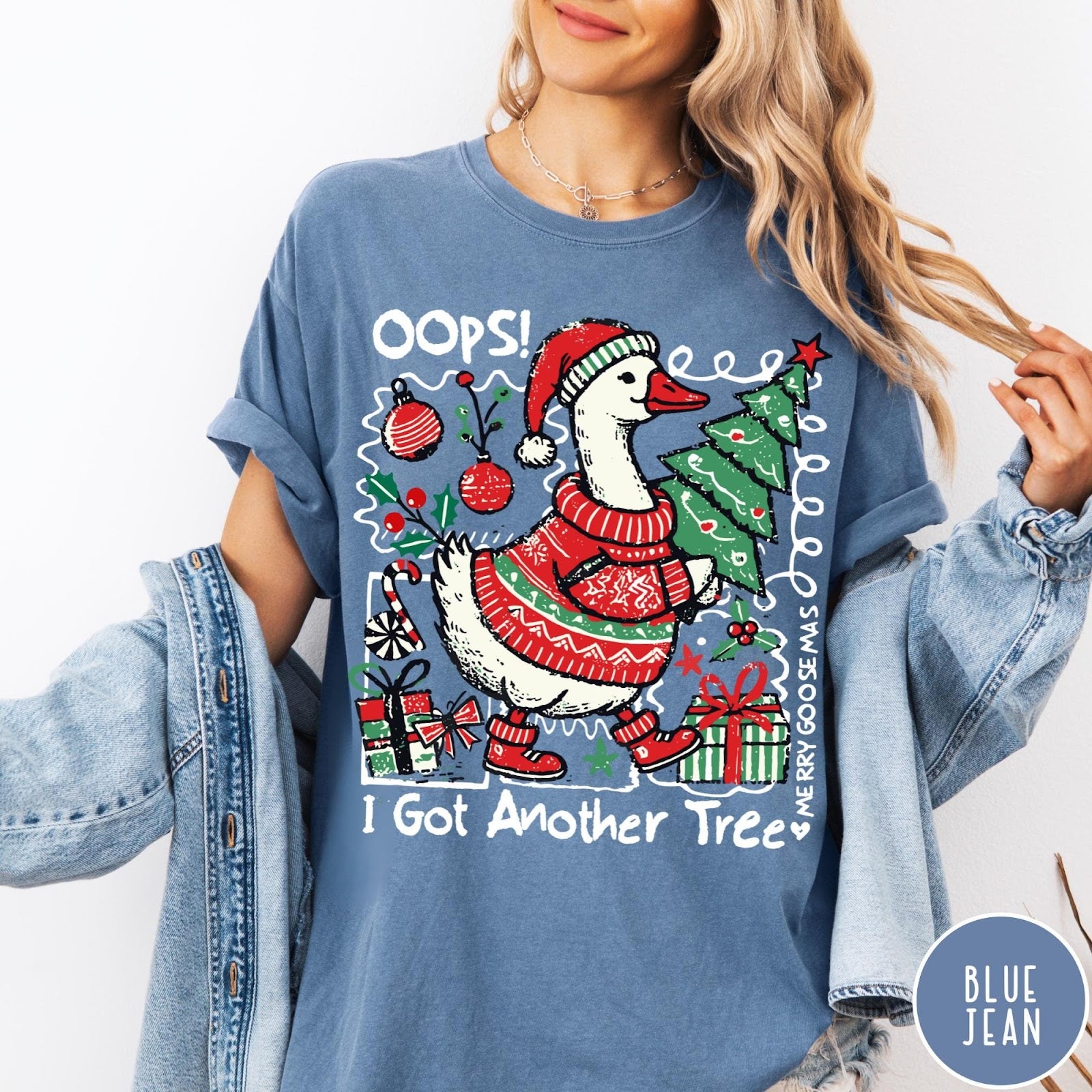 Comfort Colors tee in Blue Jean featuring festive goose graphic wearing a Santa hat and Christmas sweater holding tree