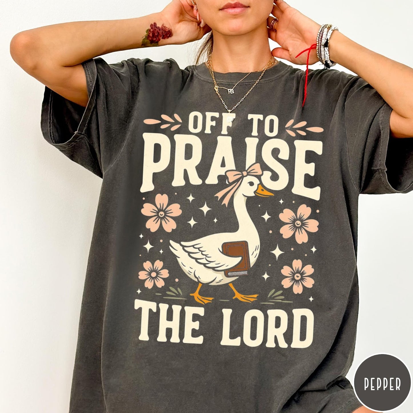 Comfort Colors tee in Pepper featuring retro style graphic of a goose wearing a bow holding a book