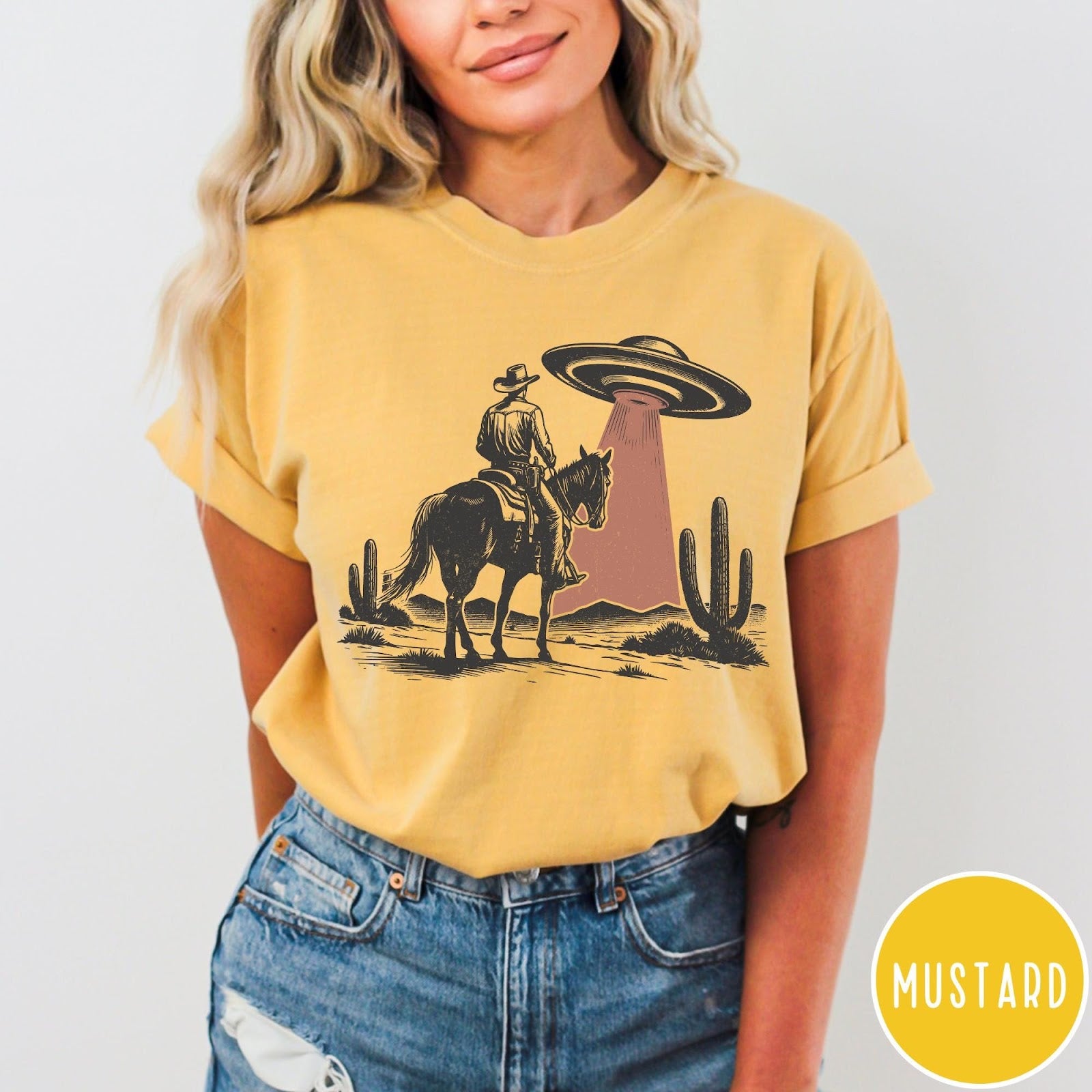 Comfort Colors tee in Mustard featuring western style graphic of a cowboy on horseback under a UFO
