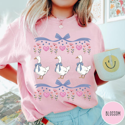 Comfort Colors tee in Blossom featuring vintage style graphic with three geese wearing blue bows and hearts