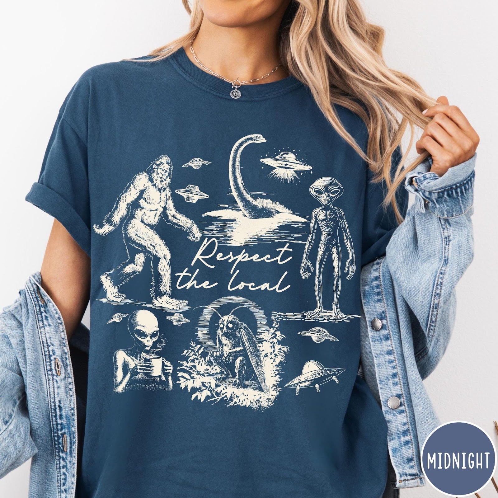 Comfort Colors tee in Midnight featuring vintage style cryptid graphic with Bigfoot, UFOs, and alien creatures.