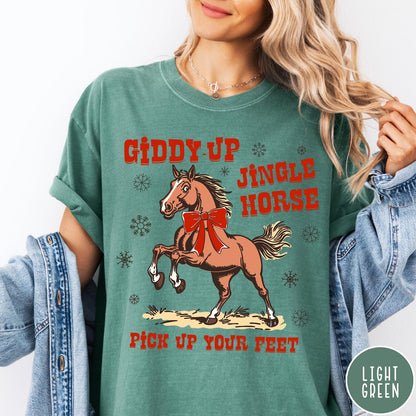 Comfort Colors tee in Light Green featuring festive holiday graphic with a prancing horse wearing a red bow