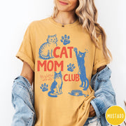 Comfort Colors tee in Mustard featuring graphic illustration of cats, paw prints, and Cat Mom Club text