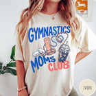 Comfort Colors tee in Ivory featuring gymnastics mom life graphic with gymnastics grips, chalk, and iced coffee