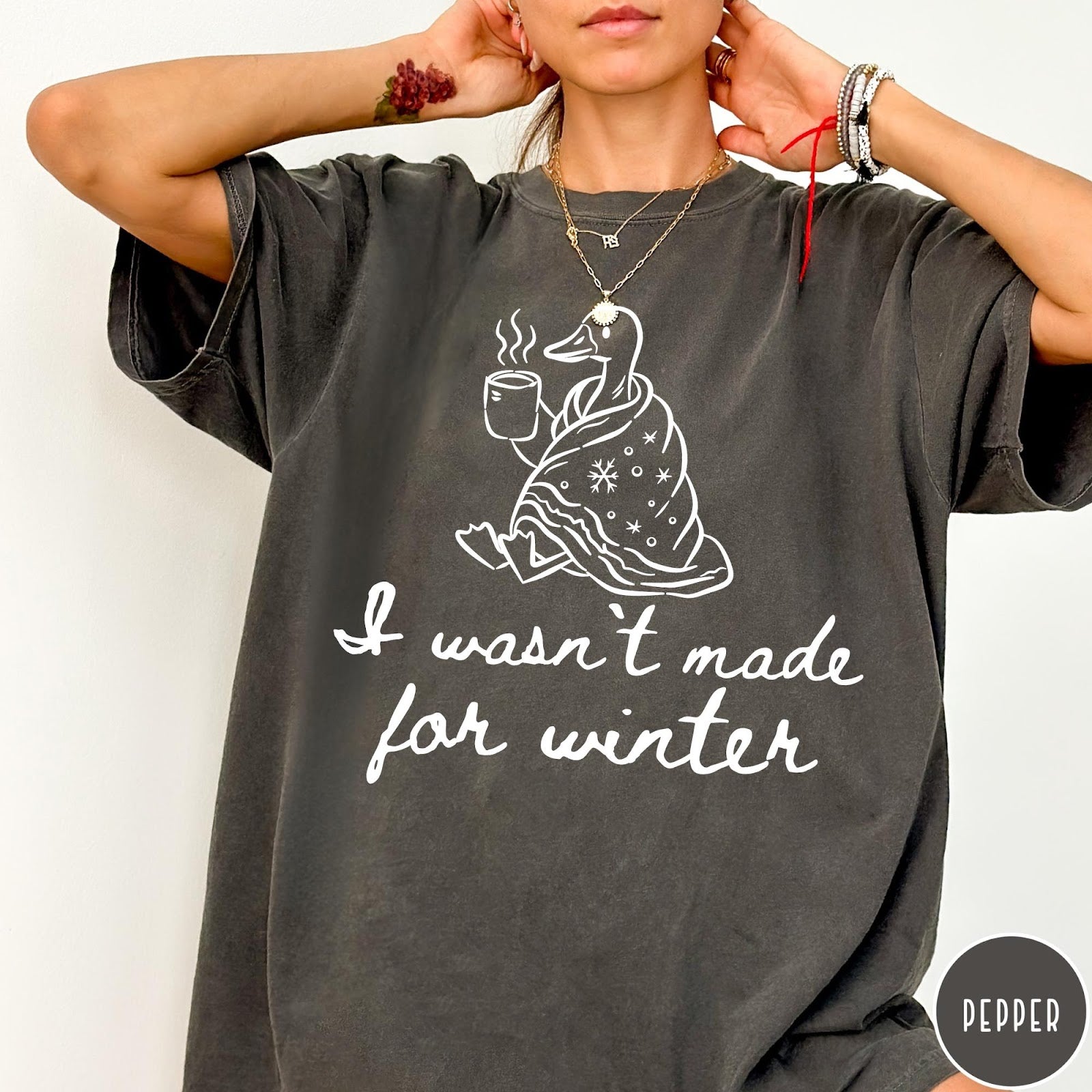 Comfort Colors tee in Pepper featuring line art graphic of a duck wrapped in a blanket drinking coffee