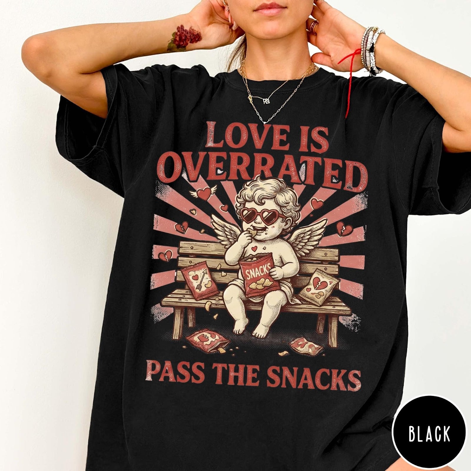 Comfort Colors tee in Black featuring vintage style graphic of a cherub eating snacks on a bench