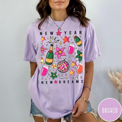 Comfort Colors tee in Orchid featuring New Year celebration graphic with champagne bottles, glasses, and disco ball