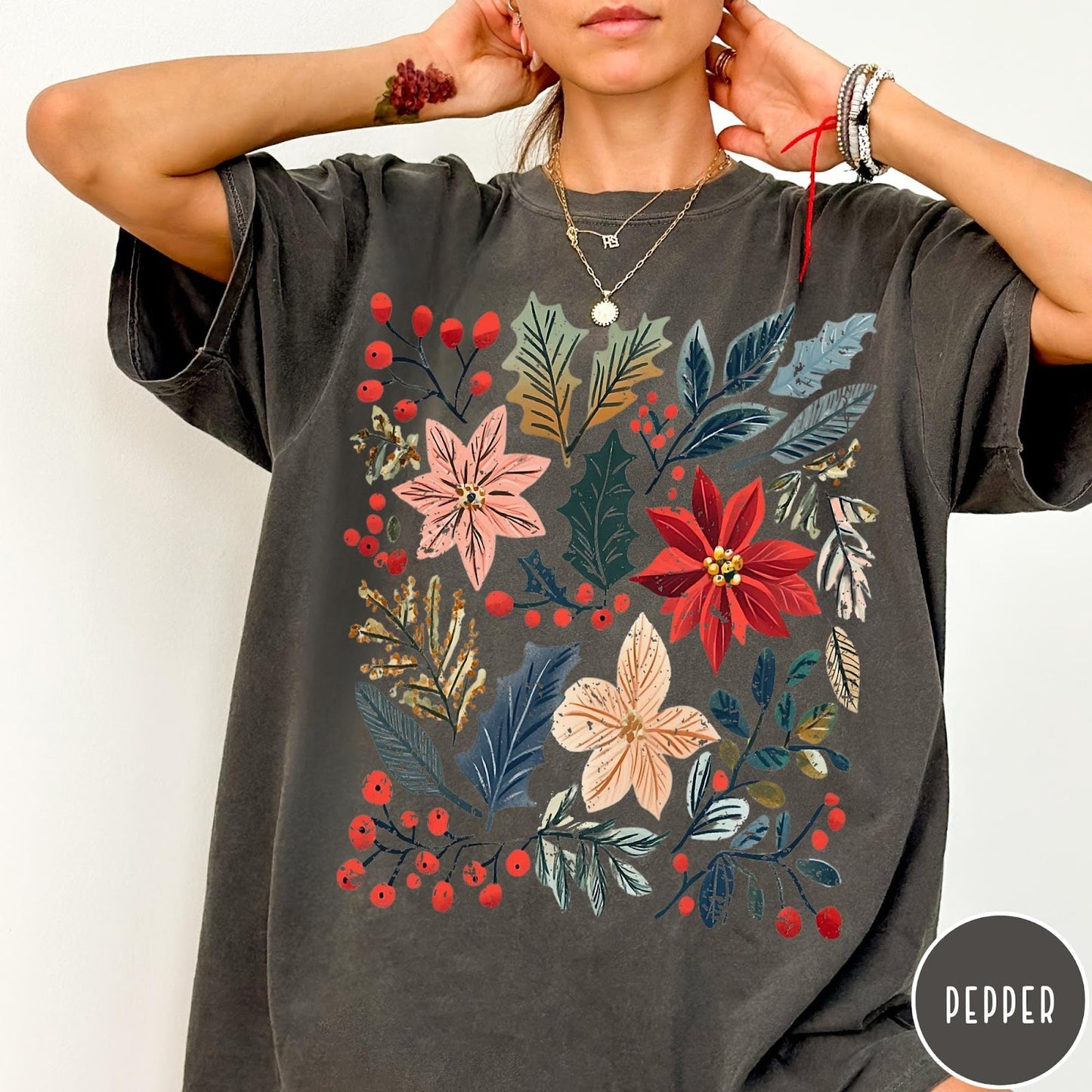Comfort Colors tee in Pepper featuring winter florals graphic with poinsettias, holly leaves, and red berries.