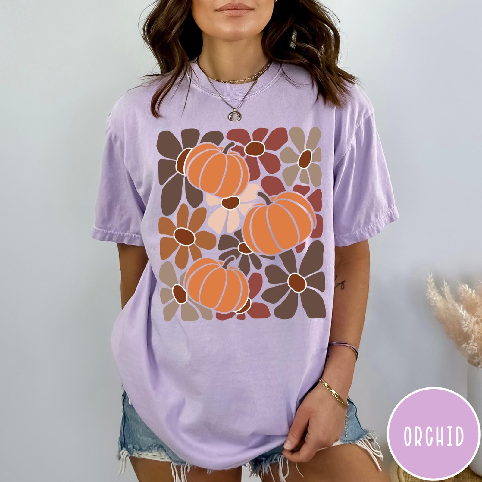 Comfort Colors tee in Orchid featuring boho floral style graphic with three orange pumpkins and brown flowers