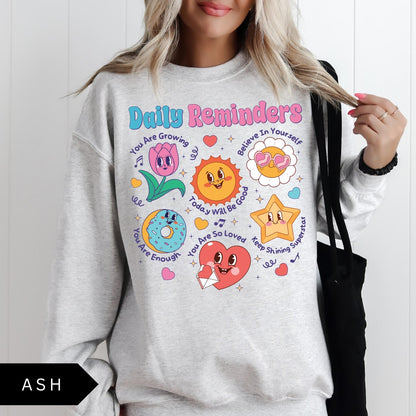 Comfort Colors tee in Ash featuring retro mascot design with daily affirmations and colorful graphics