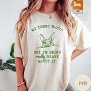 Comfort Colors tee in Ivory featuring line art graphic of a bunny with text My Tummy Hurts