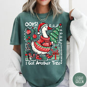 Comfort Colors tee in Light Green featuring festive goose graphic wearing a Santa hat and Christmas sweater holding tree