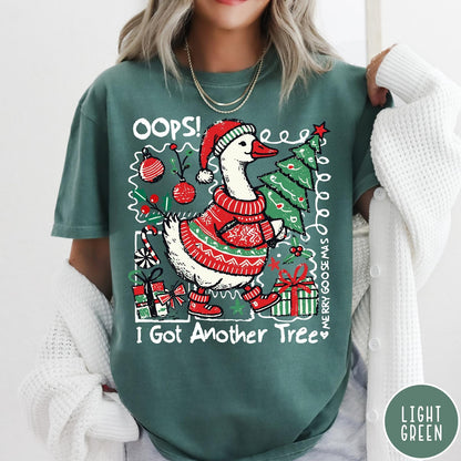 Comfort Colors tee in Light Green featuring festive goose graphic wearing a Santa hat and Christmas sweater holding tree