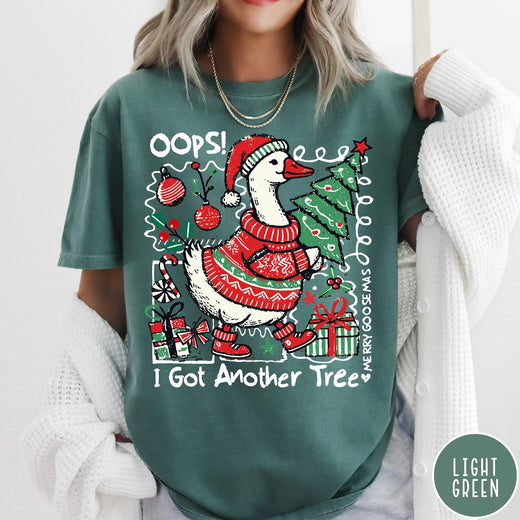 Comfort Colors tee in Light Green featuring festive goose graphic wearing a Santa hat and Christmas sweater holding tree