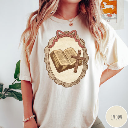 Comfort Colors tee in Ivory featuring vintage style graphic of an open Bible and wooden cross