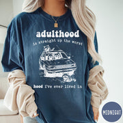 Comfort Colors tee in Midnight featuring illustrated style graphic of raccoons sitting in and around a car