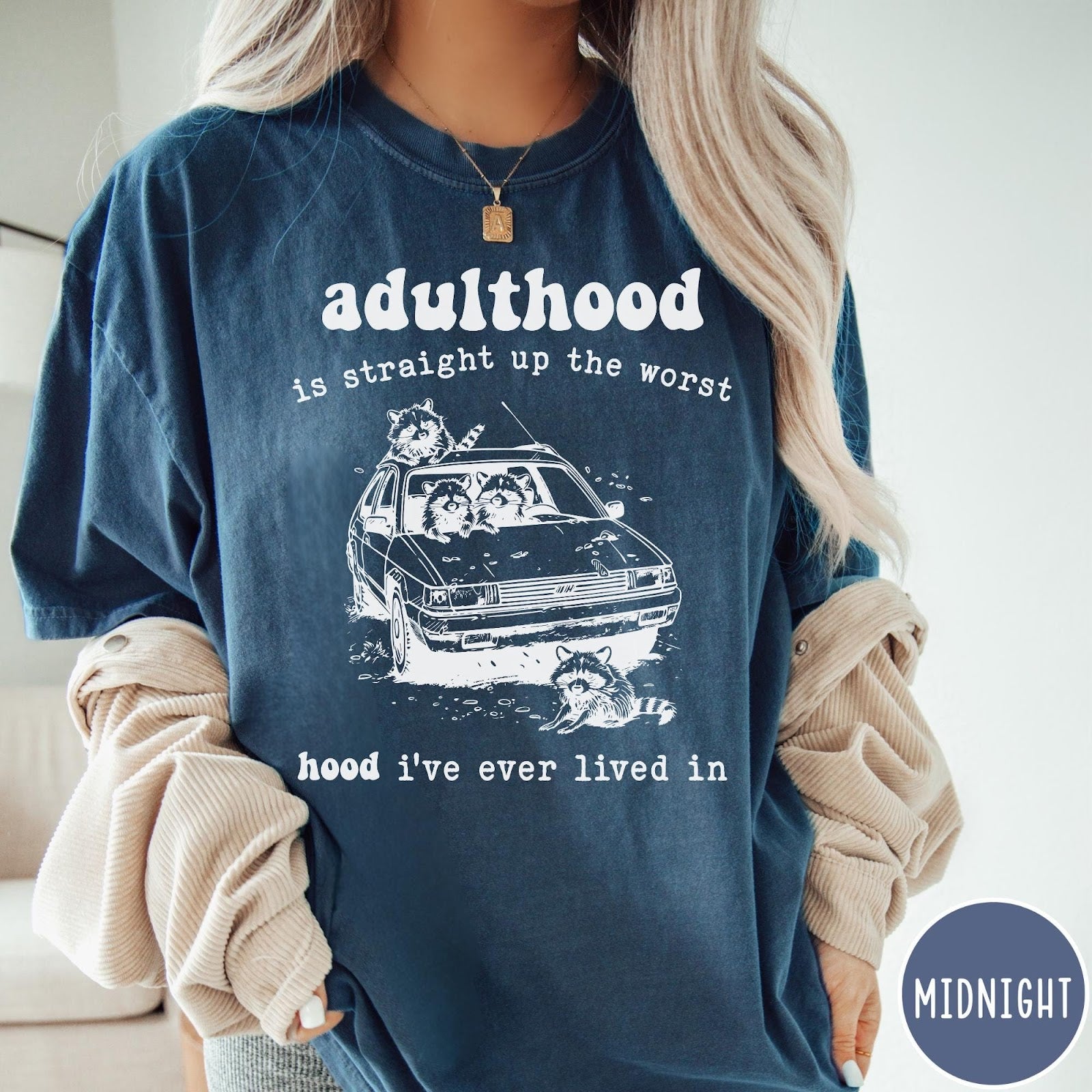 Comfort Colors tee in Midnight featuring illustrated style graphic of raccoons sitting in and around a car