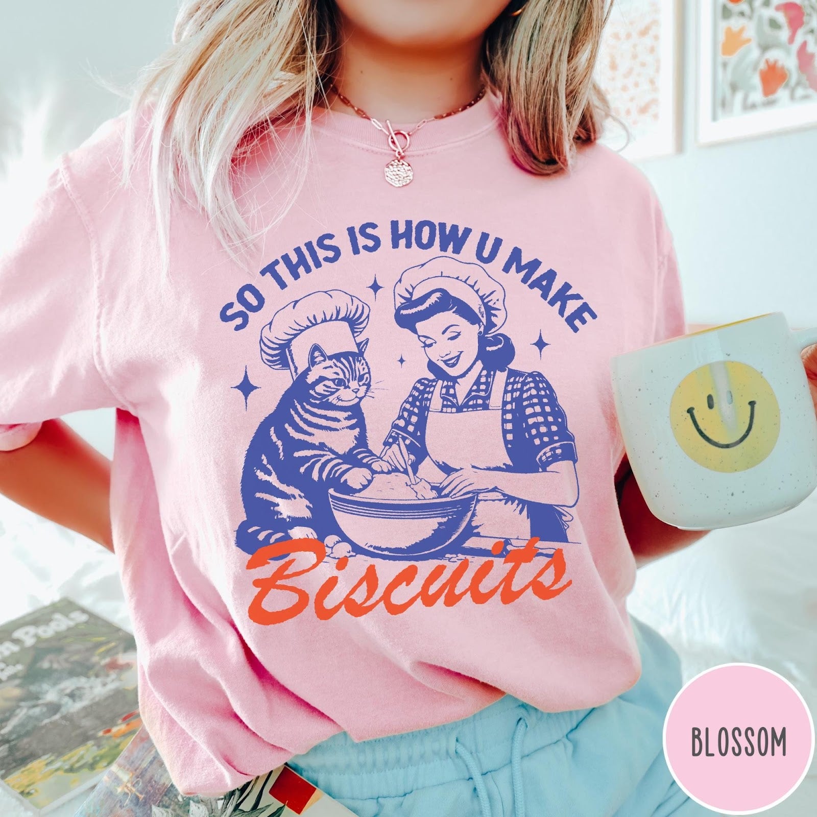 Comfort Colors tee in Blossom featuring vintage style graphic of a woman and cat baking biscuits together