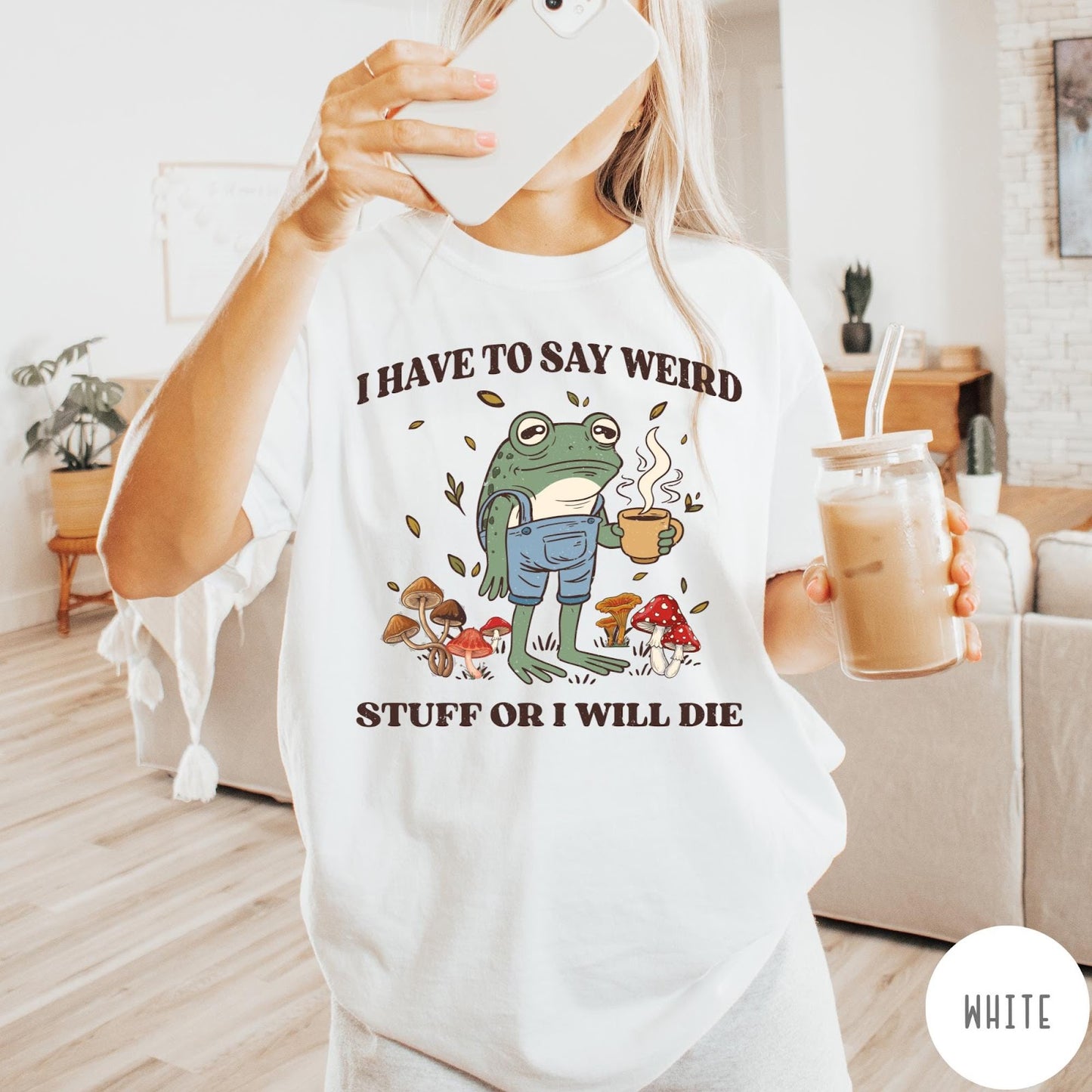 Comfort Colors tee in White featuring cartoon style frog wearing overalls holding a coffee mug with mushrooms
