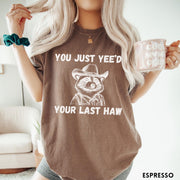 Comfort Colors tee in Espresso featuring western style graphic of a raccoon wearing a cowboy hat