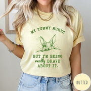 Comfort Colors tee in Butter featuring line art graphic of a bunny with text My Tummy Hurts