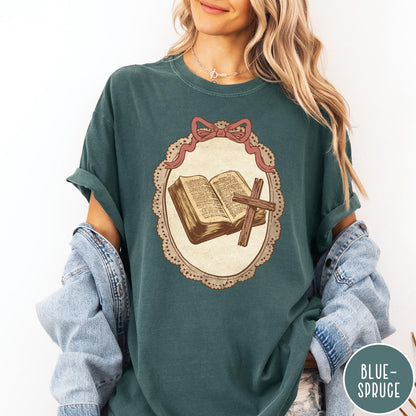 Comfort Colors tee in Blue Spruce featuring vintage style graphic of an open Bible and wooden Christian cross.