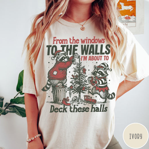 Comfort Colors tee in Ivory featuring vintage style graphic of two raccoons decorating a Christmas tree with trash.