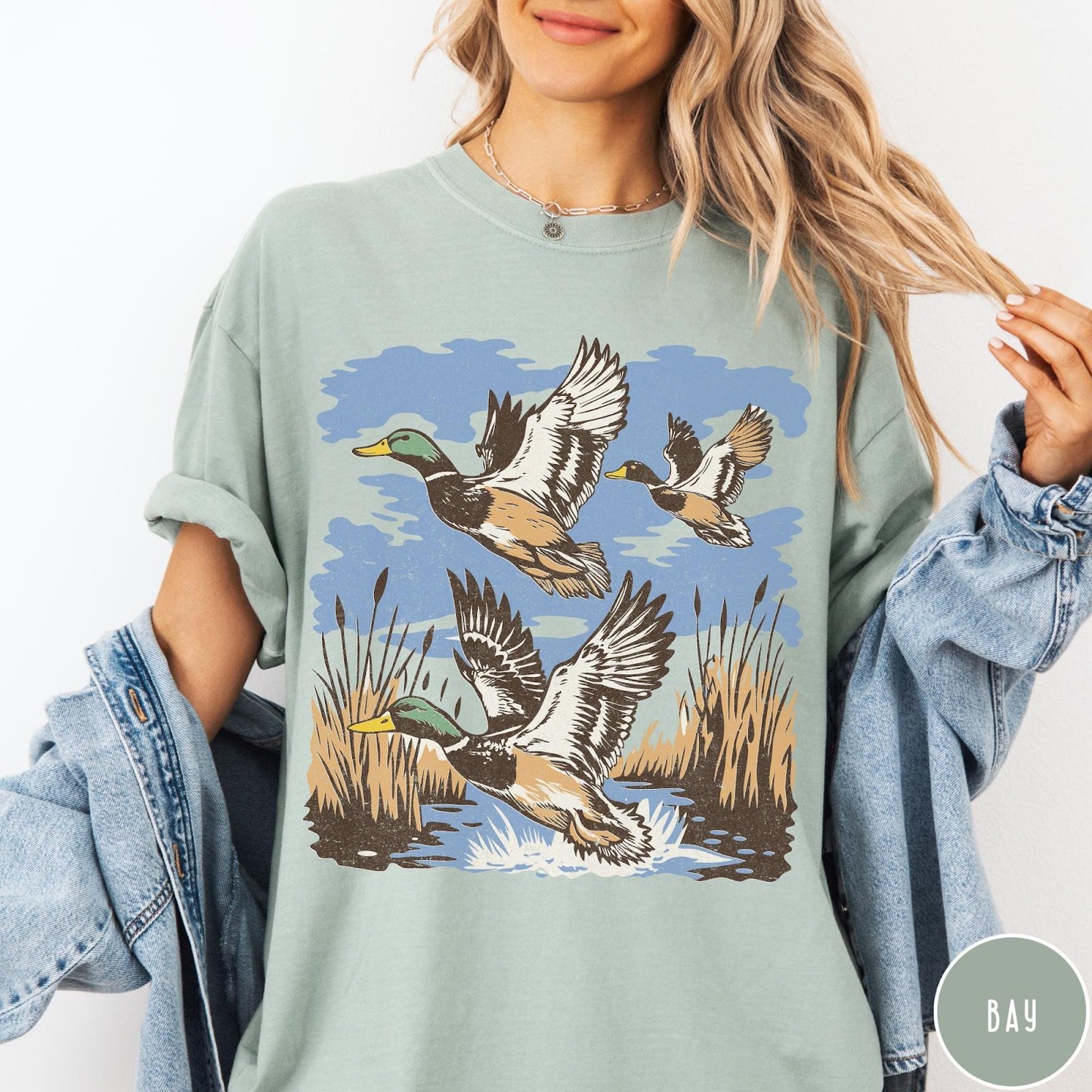 Comfort Colors tee in Bay featuring vintage style mallard ducks flying over a marshy pond graphic