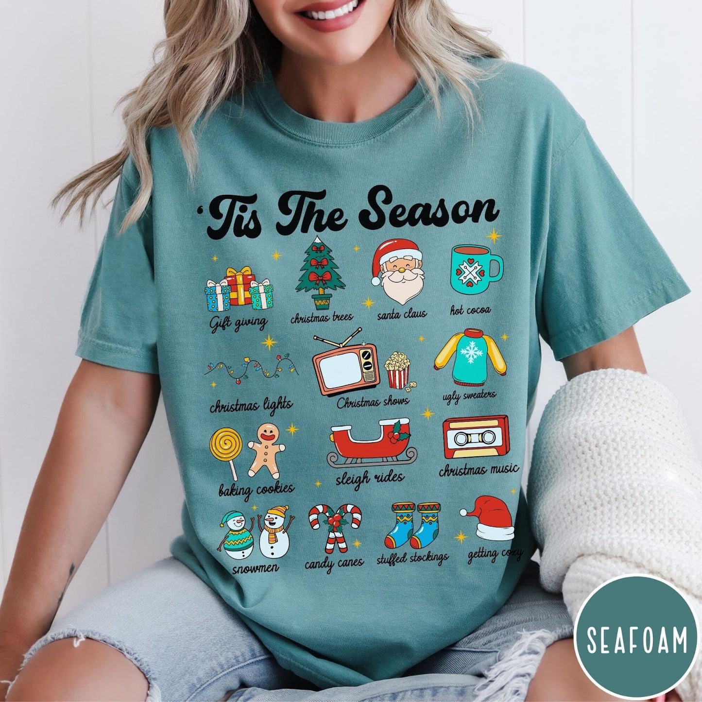 Comfort Colors tee in Seafoam featuring holiday icons graphic with Christmas trees, Santa, and festive seasonal imagery