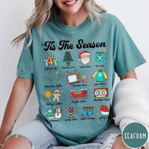 Comfort Colors tee in Seafoam featuring holiday icons graphic with Christmas trees, Santa, and festive seasonal imagery