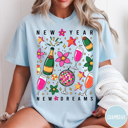 Comfort Colors tee in Chambray featuring New Year celebration graphic with champagne bottles, glasses, and disco ball