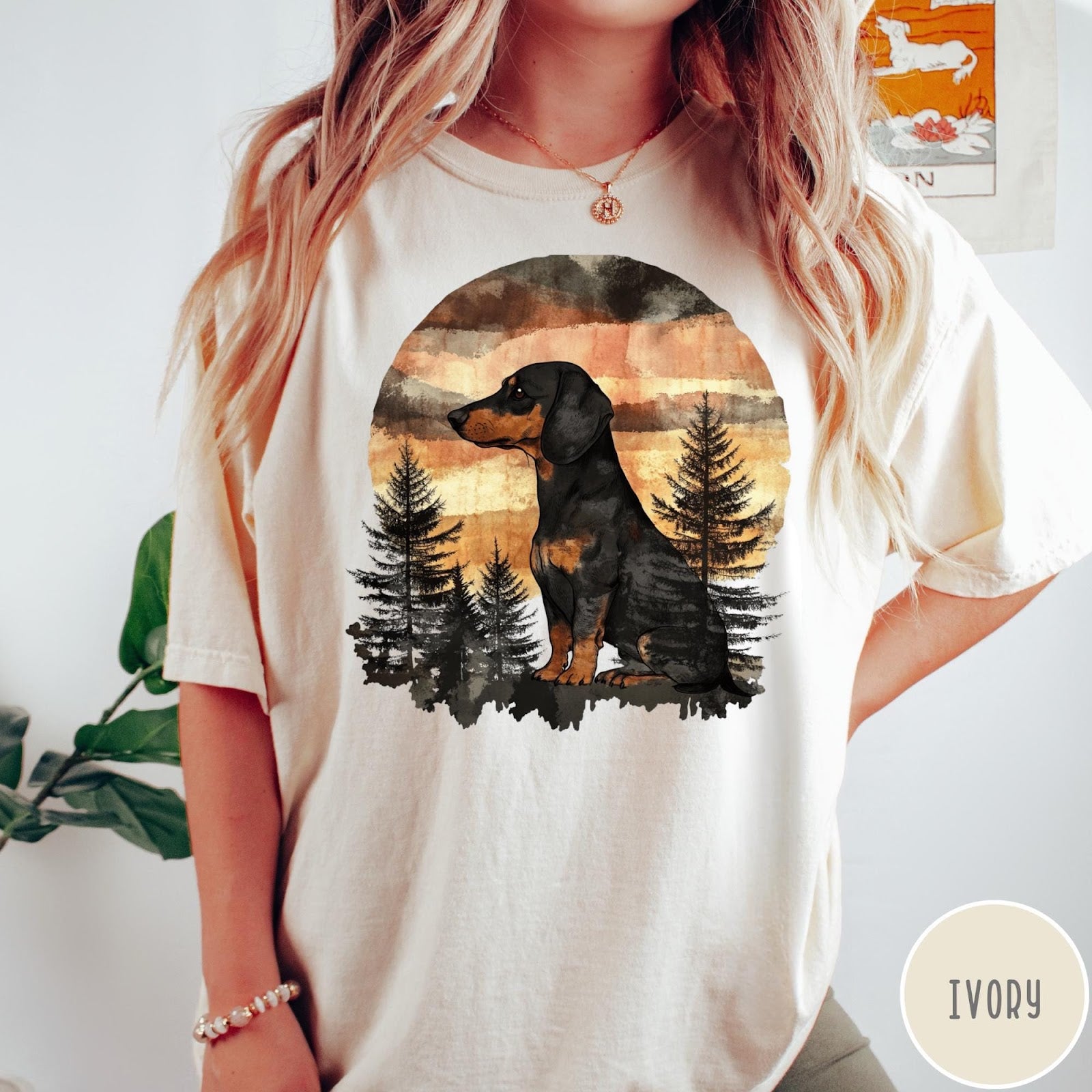 Comfort Colors tee in Ivory featuring vintage style graphic of a dachshund sitting in a forest sunset
