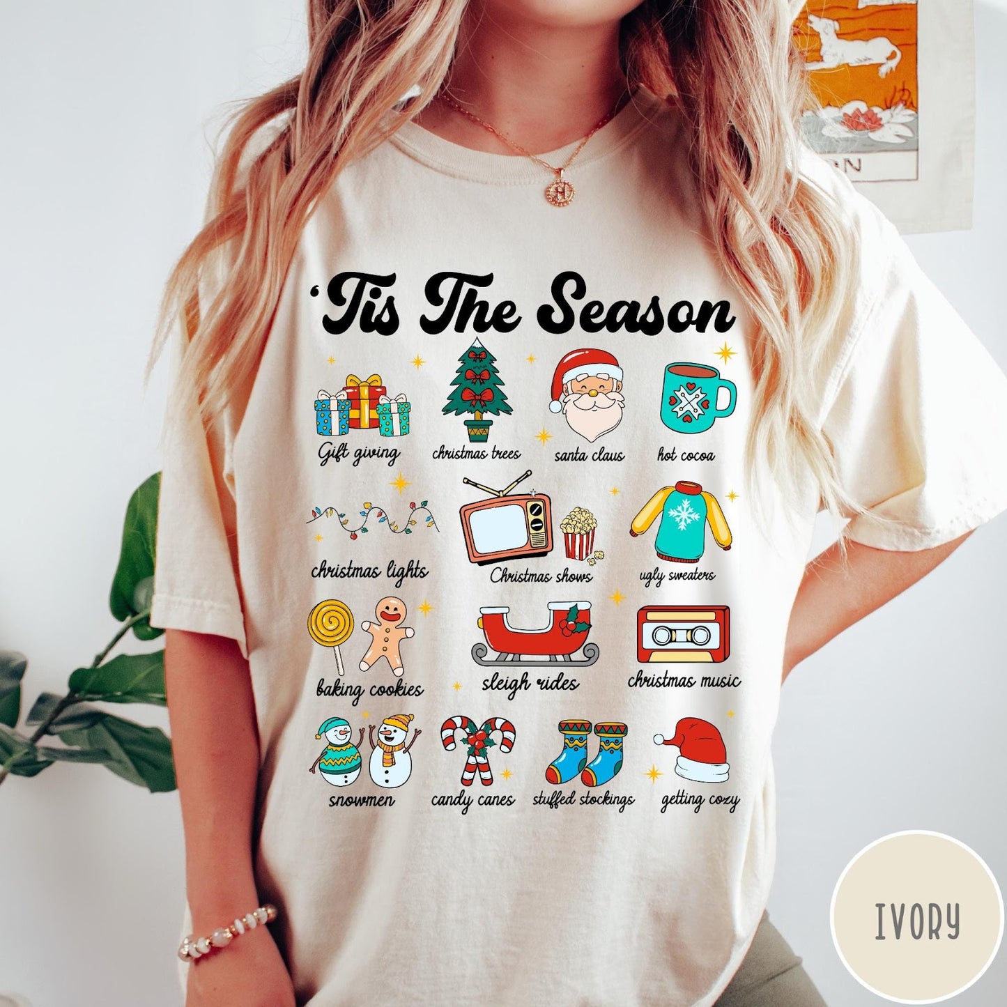 Comfort Colors tee in Ivory featuring holiday icons graphic with Christmas trees, Santa, and festive seasonal imagery