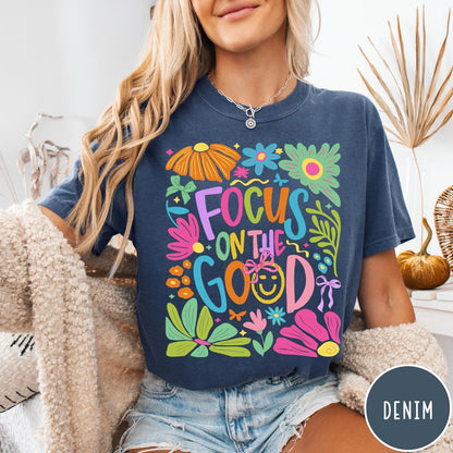 Comfort Colors tee in Denim featuring positivity typography and floral collage graphic with a smiley face.