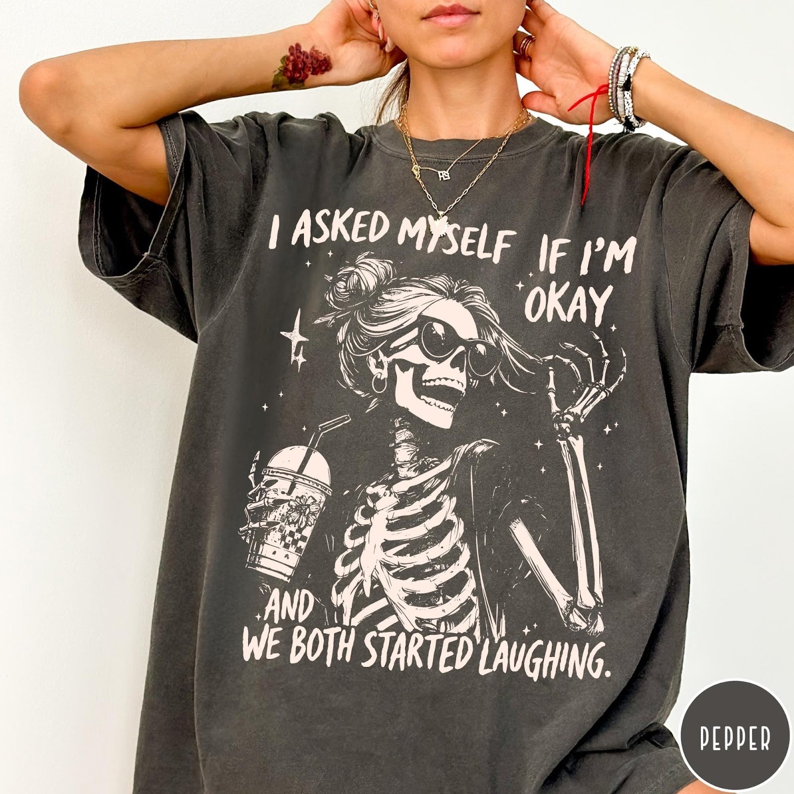 Comfort Colors tee in Pepper featuring skeleton design with sunglasses and iced coffee with laughing text graphic