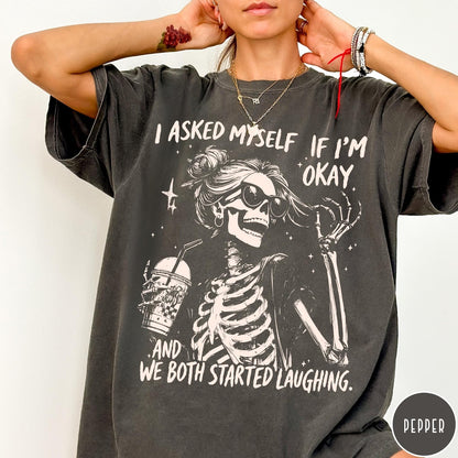Comfort Colors tee in Pepper featuring skeleton design with sunglasses and iced coffee with laughing text graphic
