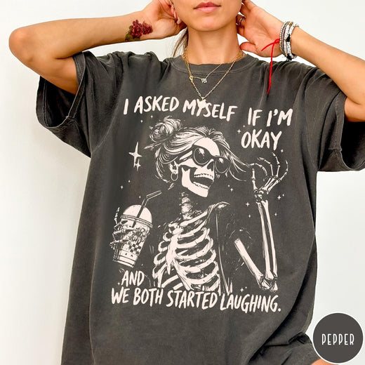 Comfort Colors tee in Pepper featuring skeleton design with sunglasses and iced coffee with laughing text graphic