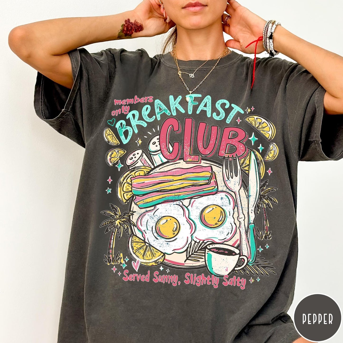 Comfort Colors tee in Pepper featuring breakfast food graphic with bacon, eggs, coffee, and palm trees.