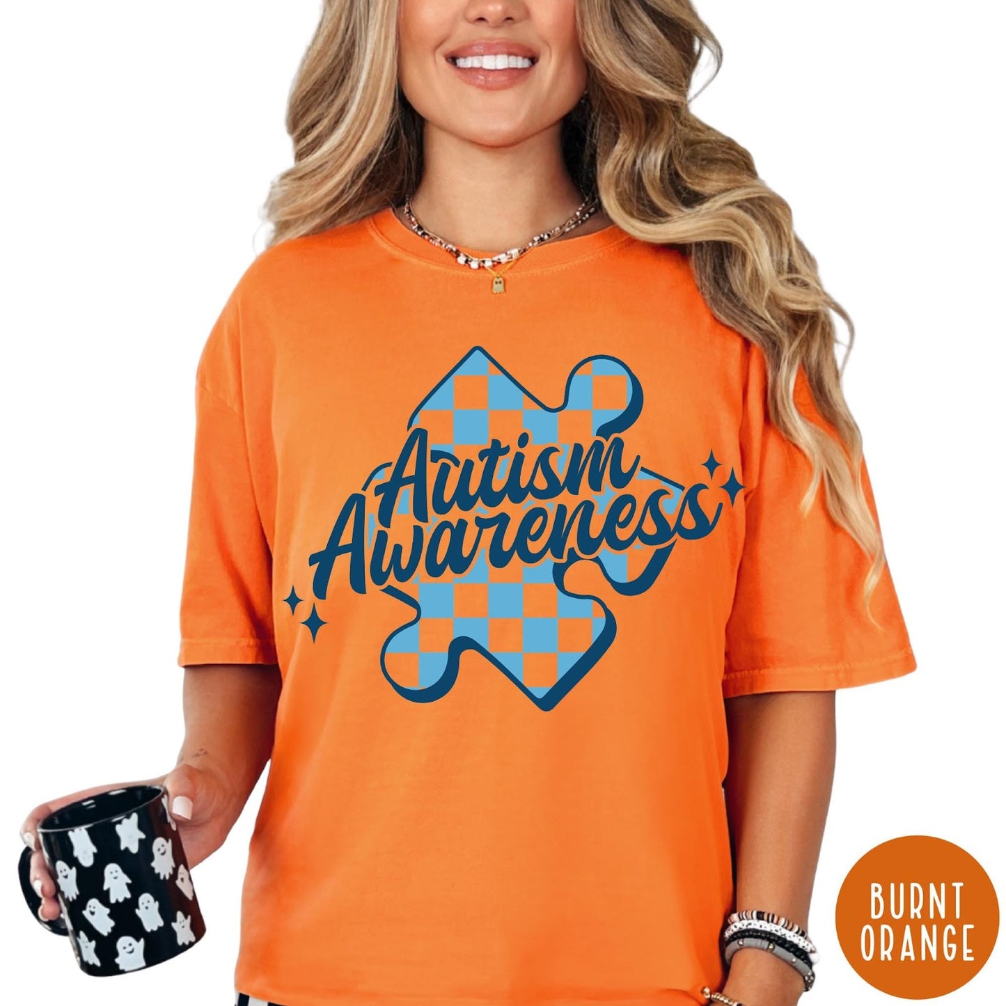 Comfort Colors tee in Burnt Orange featuring screen print style Autism Awareness puzzle piece with blue checkerboard pattern