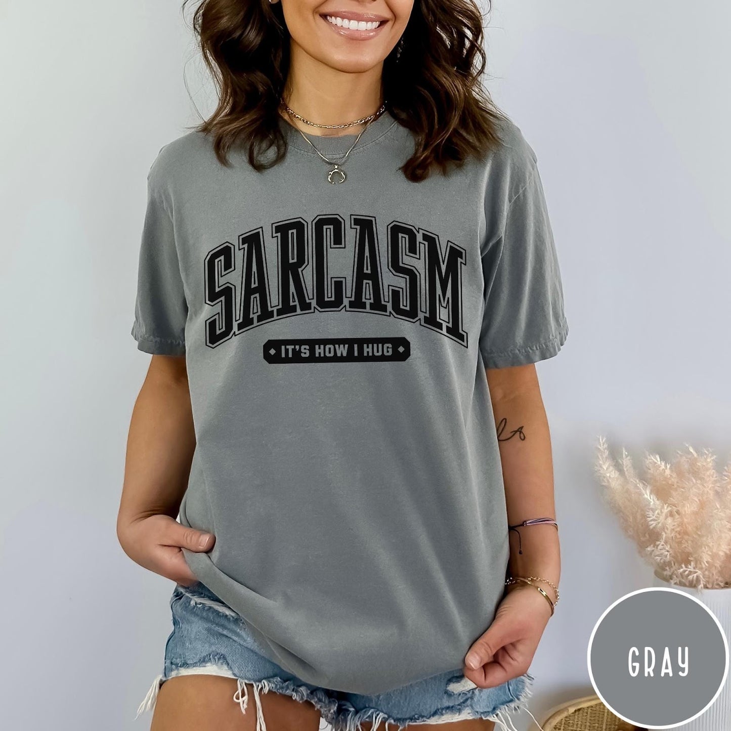 Comfort Colors tee in Gray featuring collegiate style text reading Sarcasm It's How I Hug