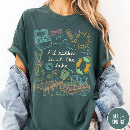 Comfort Colors tee in Blue Spruce featuring lake vacation graphic with pontoon boat, dock, and summer accessories
