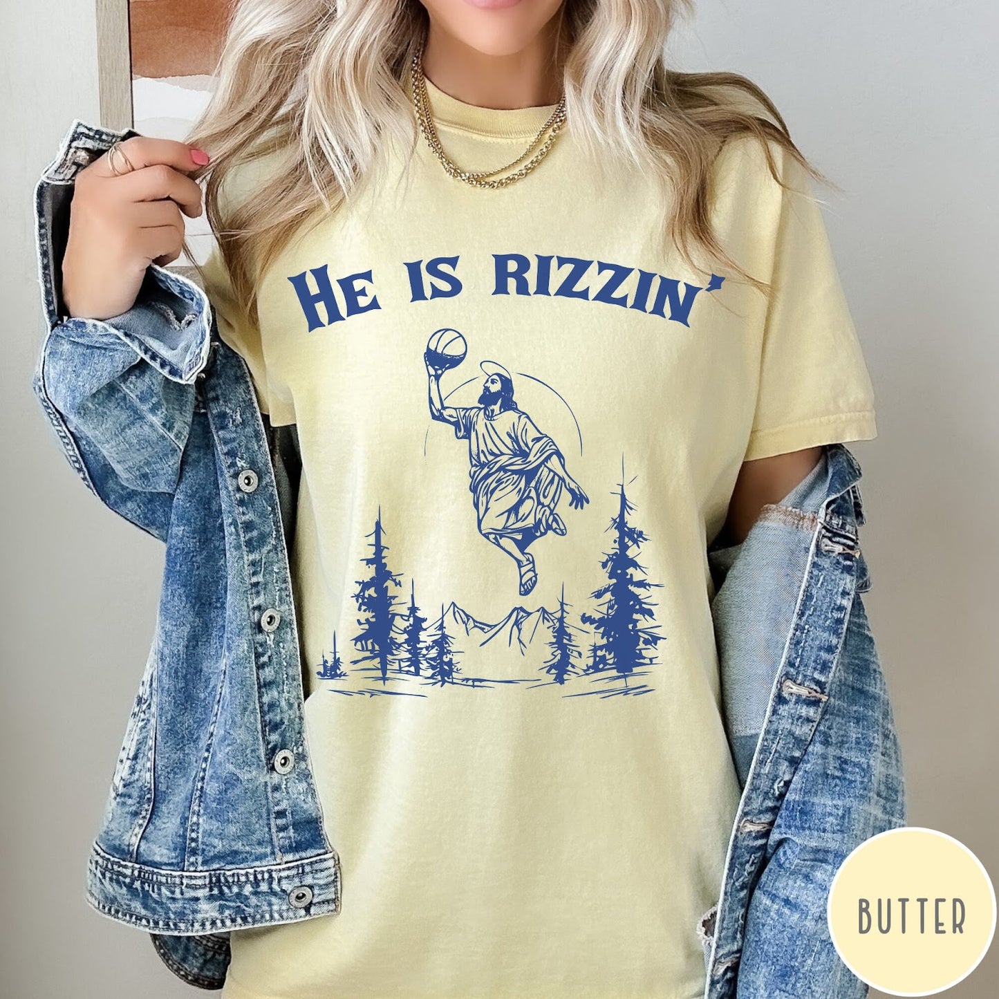 Comfort Colors tee in Butter featuring graphic style Jesus playing basketball with mountains and pine trees illustration