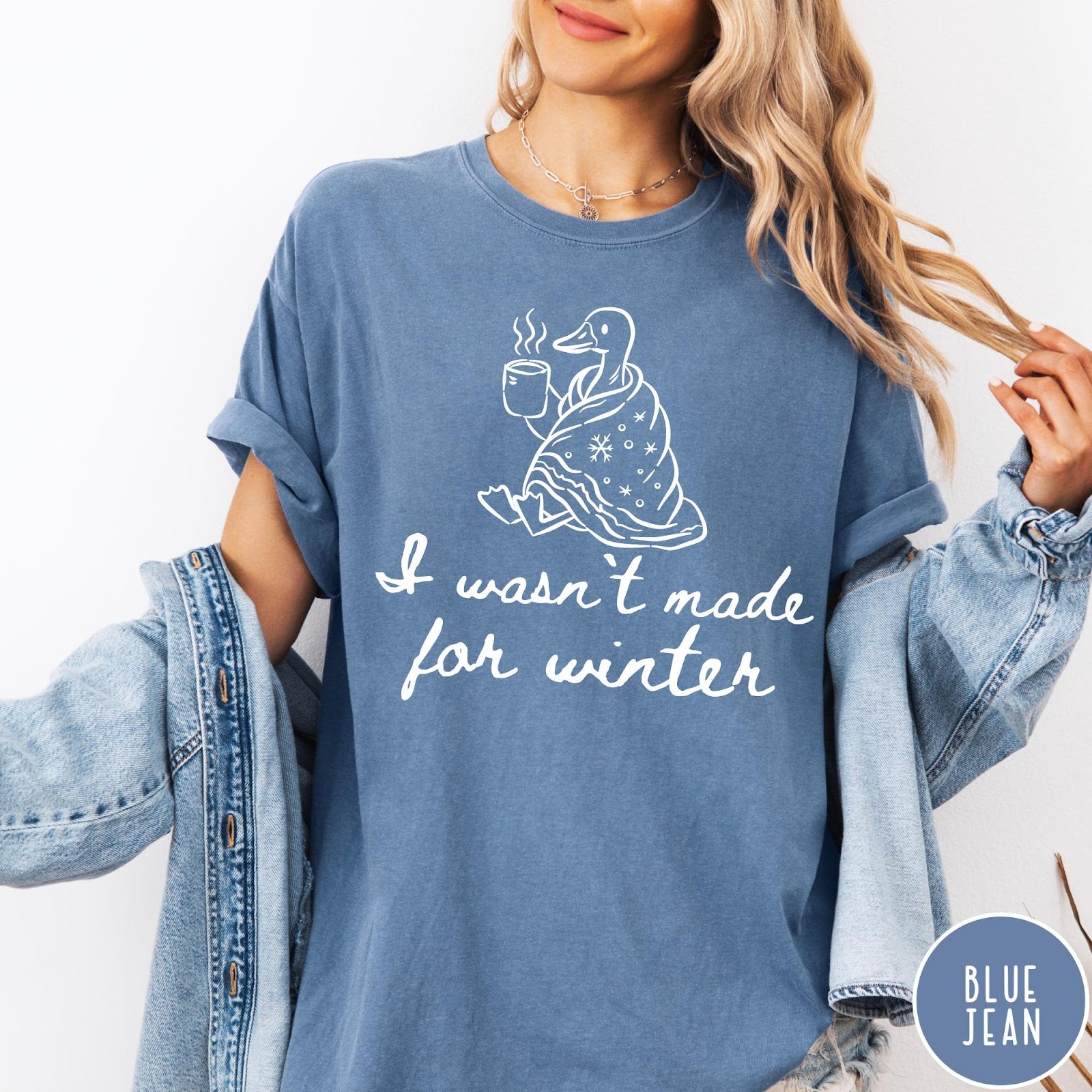 Comfort Colors tee in Blue Jean featuring line art graphic of a duck wrapped in a blanket drinking coffee
