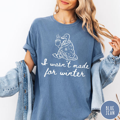 Comfort Colors tee in Blue Jean featuring line art graphic of a duck wrapped in a blanket drinking coffee