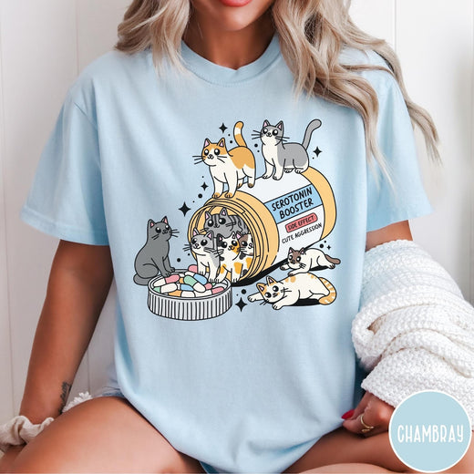 Comfort Colors tee in Chambray featuring graphic illustration of cats spilling out of a serotonin booster bottle
