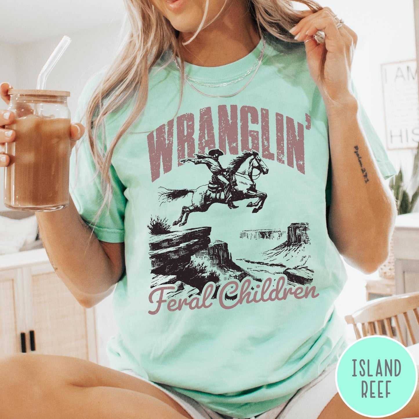 Comfort Colors tee in Island Reef featuring western style graphic of a cowboy on horseback jumping a canyon
