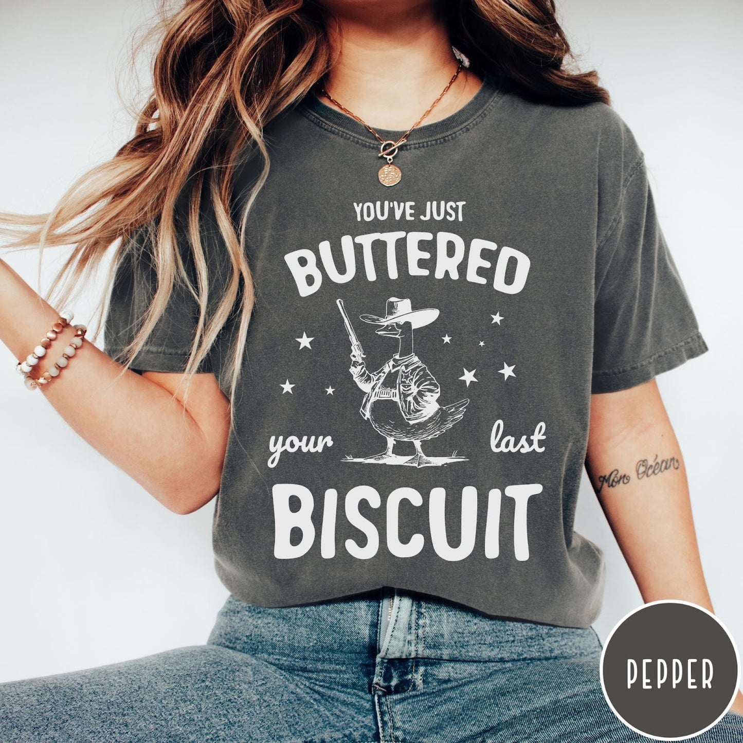 Comfort Colors tee in Pepper featuring western graphic style cowboy goose holding a revolver with star accents